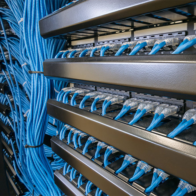 Un homme branche un câble cuivre/fibre optique pour la téléphonie IP