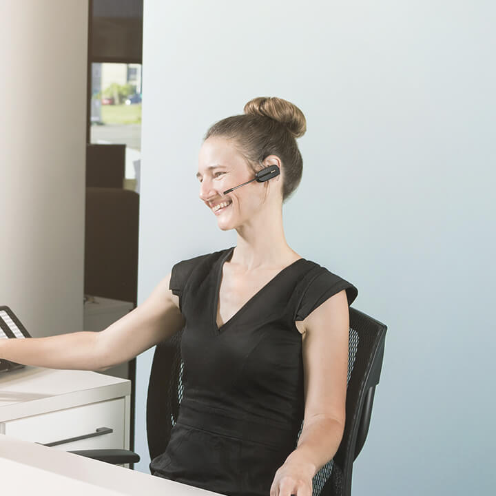 Une femme discute au téléphone avec une oreillette grâce à la téléphonie IP