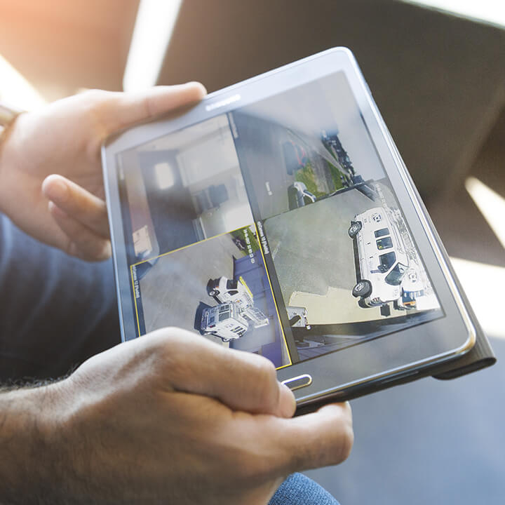 Une personne regarde sur une tablette les enregistrements des caméras de sécurité